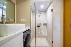 La salle de bains est pourvue d'un lavabo et d'une douche. dans l'établissement Boutique houtel Shanghai Lujiazui, à Shanghai