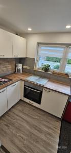 a kitchen with white cabinets and a large window at Dat Niehuus Tarnewitz in Boltenhagen