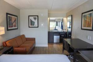 um quarto de hotel com um sofá e uma sala de estar em Boardwalk Suites Baton Rouge em Baton Rouge
