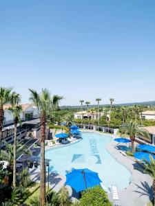 an aerial view of a resort pool with palm trees at Hotel Toscana in Seogwipo