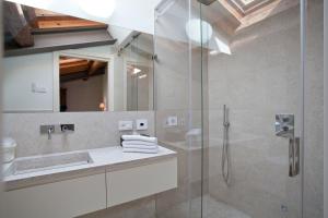 a bathroom with a sink and a glass shower at Relais Corte Guastalla Apartments in Sona
