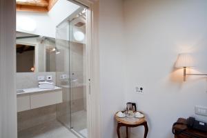 a bathroom with a glass shower and a sink at Relais Corte Guastalla Apartments in Sona