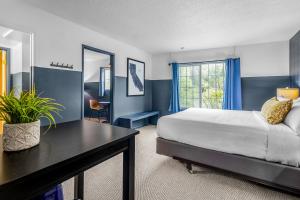 a bedroom with a bed and a desk and a window at The Angler Lodge in Dunsmuir +20 photos