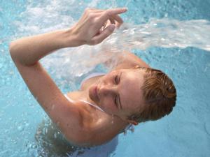 um jovem a nadar na água numa piscina em Luxury chalet in Zillertal em Aschau