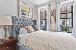 a bedroom with a bed and two windows at Spacious 4 Bedroom Apartment in New York