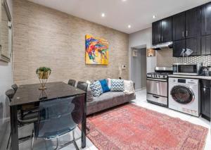 eine Küche und ein Wohnzimmer mit einem Sofa und einem Tisch in der Unterkunft Spacious 4 Bedroom Apartment in New York