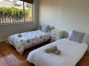 Duas camas num quarto com uma janela em Home in Brighton em Melbourne
