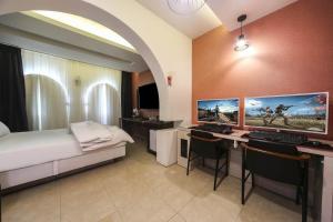 a bedroom with a bed and a desk with two monitors at Hwamyeong Sky Hotel in Busan +24 photos