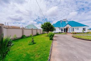 a large white house with a blue roof at Teranga Lodge and Restaurant in Ihumwa