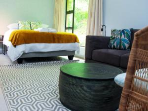a living room with a bed and a coffee table at Incwala Lodge in Waterval Boven