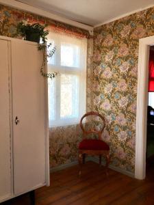 a chair in a room with floral wallpaper at Romantic Seaside House in Pärnu