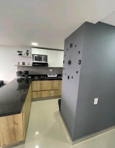 een keuken met een muur met een fornuis en een magnetron bij Roldan House in Sabaneta