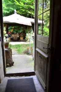 una porta aperta che conduce a un cortile con ombrellone di Les anciens thermes a Soultzbach-les-Bains