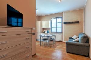a living room with a couch and a tv and a table at Sara al Lago - con garage e WiFi in Sirmione