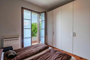 a bedroom with a bed and a large window at Sara al Lago - con garage e WiFi in Sirmione