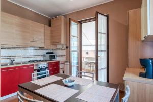 a kitchen with red cabinets and a table in it at Sara al Lago - con garage e WiFi in Sirmione