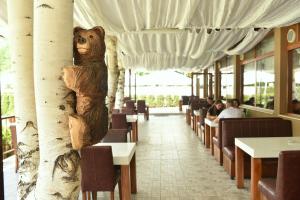a bear carved out of a tree in a restaurant at Почивен комплекс Минкови бани in Spantschewzi