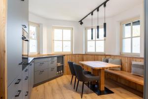 a kitchen with a wooden table and chairs at Oberwinklgut in Bischofshofen