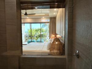 a reflection of a bedroom with a bed in a mirror at Canopus Retreat Thulusdhoo in Thulusdhoo