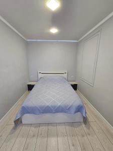 una camera bianca con un letto e due tavoli di Двухкомнатная квартира на Ауезова a Kökşetaw
