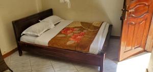 a bed in a room with a wooden frame at Geoflo Motel in Mityana