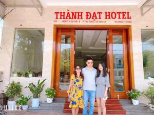 three people standing in front of a thank dat hotel at Thành Đạt Hotel in Cửa Lô +5 photos