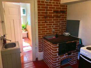 a kitchen with a brick wall and a sink at Romantic Seaside House in Pärnu