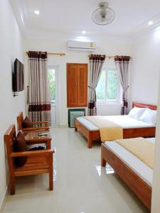 a bedroom with two beds and a tv in it at Thành Đạt Hotel in Cửa Lô