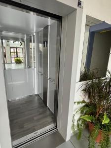 a glass door leading into a hallway with plants at Studio calais la plage in Calais