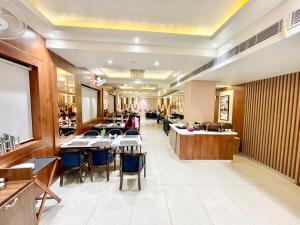 a restaurant with tables and chairs in a room at HOTEL VEDANGAM INN ! VARANASI - Forɘigner's Choice ! fully Air-Conditioned hotel with Parking availability, near Kashi Vishwanath Temple, and Ganga ghat 2 in Varanasi