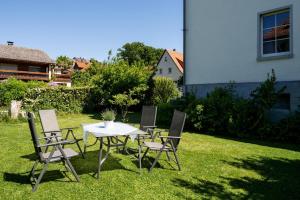 a table and chairs sitting in the grass at Villa am Edersee in Hemfurth-Edersee