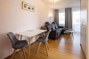 een woonkamer met een bank en een tafel en stoelen bij Kleine SeePause am Edersee in Scheid