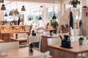 a restaurant with tables and chairs and a surfboard on the counter at Seeblick genießen in schöner FeWo am Edersee in Scheid