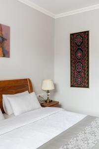a bedroom with a bed and a table with a lamp at Soluxe Hotel in Bishkek