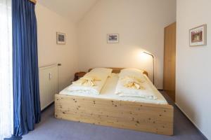 a bedroom with a wooden bed with blue curtains at Fewo am Edersee mit 2 Schlafzimmern in Scheid