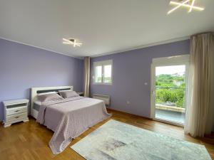 a bedroom with a bed and a large window at Krimovica Sunset Spacious Apartment with Sea View and Pool in Krimovice