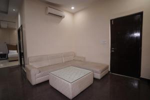 uma sala de estar com um sofá e um repousa-pés em Nirmal Hotel And Resort em Bareilly
