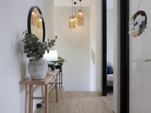 a hallway with a potted plant and a mirror at Villa pak joni in Pasuruan
