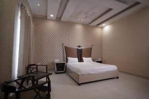 um quarto com uma cama e duas cadeiras em Nirmal Hotel And Resort em Bareilly