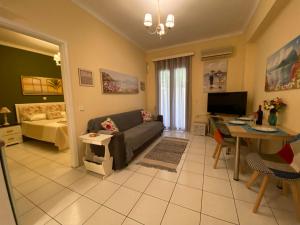 una sala de estar con un sofá y una mesa en The Green Apartment, 1 min walk from Kalamaki beach, en Kalamaki