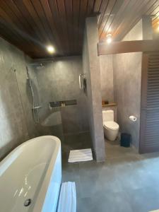 La salle de bains est pourvue d'une baignoire et de toilettes. dans l'établissement Tegal Sari Accommodation Ubud, à Ubud
