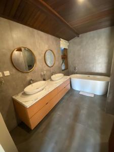 La salle de bains est pourvue de 2 lavabos et d'une baignoire. dans l'établissement Tegal Sari Accommodation Ubud, à Ubud
