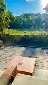 a wooden picnic table with a view of a field at Tegal Sari Accommodation Ubud in Ubud