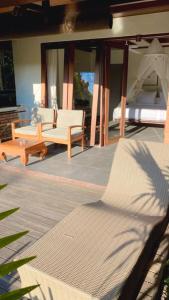 a patio with a bed and a couch and a table at Tegal Sari Accommodation Ubud in Ubud
