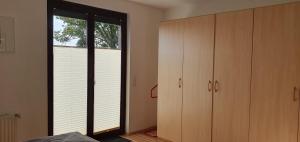 a bedroom with a large window and a closet at Ferienwohnung in Etelsen in Langwedel