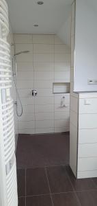 a bathroom with a shower and a tile floor at Ferienwohnung in Etelsen in Langwedel