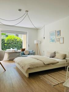 1 dormitorio blanco con 1 cama grande y 1 silla en Seelaxing, en Lindau