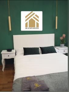 ein Schlafzimmer mit einem weißen Bett und zwei weißen Tischen in der Unterkunft LM apartments Puentezuelas in Granada