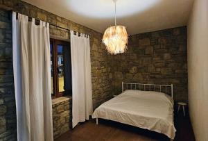 a bedroom with a bed and a stone wall at Villa Toscana in Gokceada Town