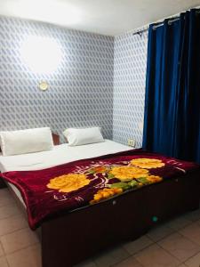 a bedroom with a bed with a flower blanket on it at Misty Meadows in Ooty